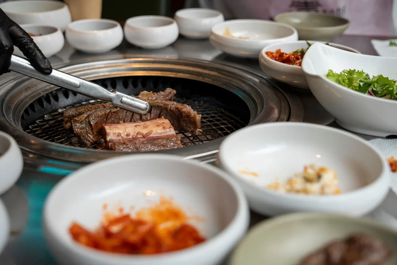 삿포로 스스키노 식당에서 구워지는 신선한 양고기와 채소의 먹음직스러운 모습입니다.