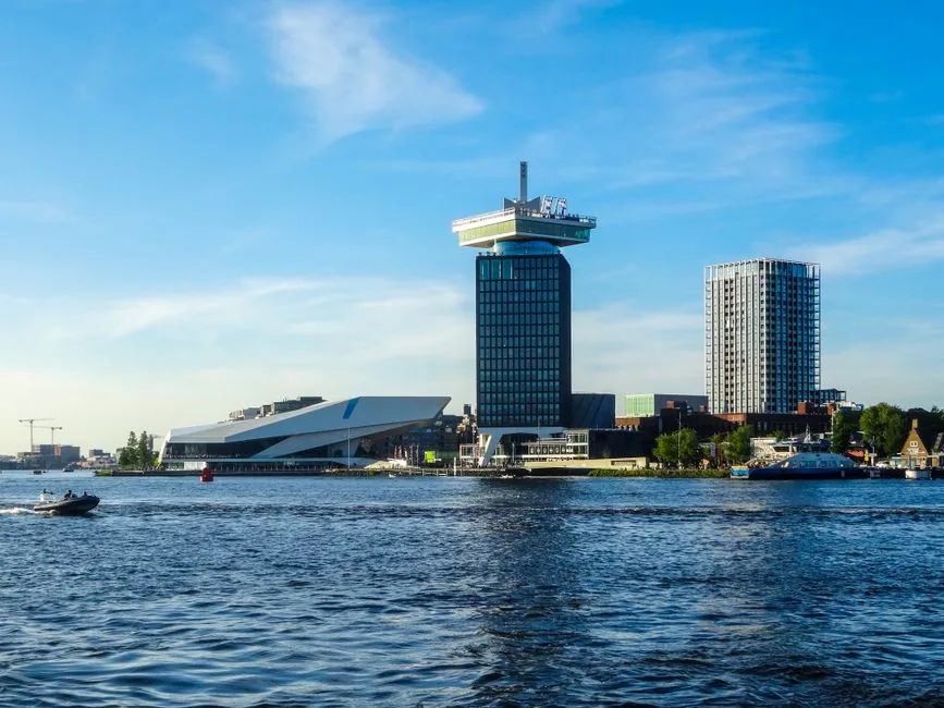 The panoramic view of the Amsterdam city skyline from the top of the A'DAM Lookout during golden hour.