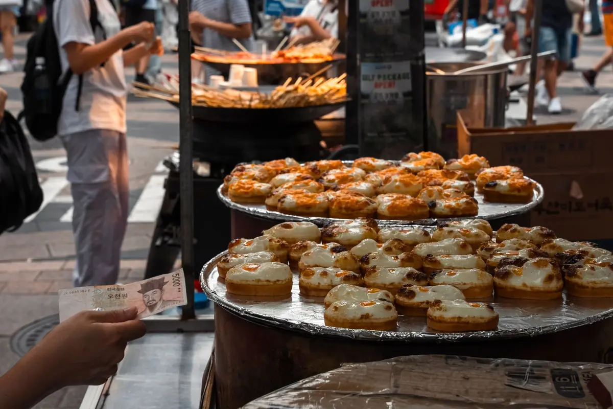 A close-up of a local market stall displaying fresh seafood and traditional Korean side dishes common in Tongyeong.