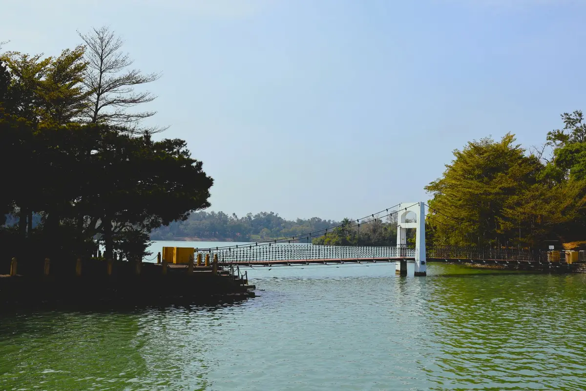 The long, wooden-decked suspension bridge stretching across the calm waters of Majang Lake.