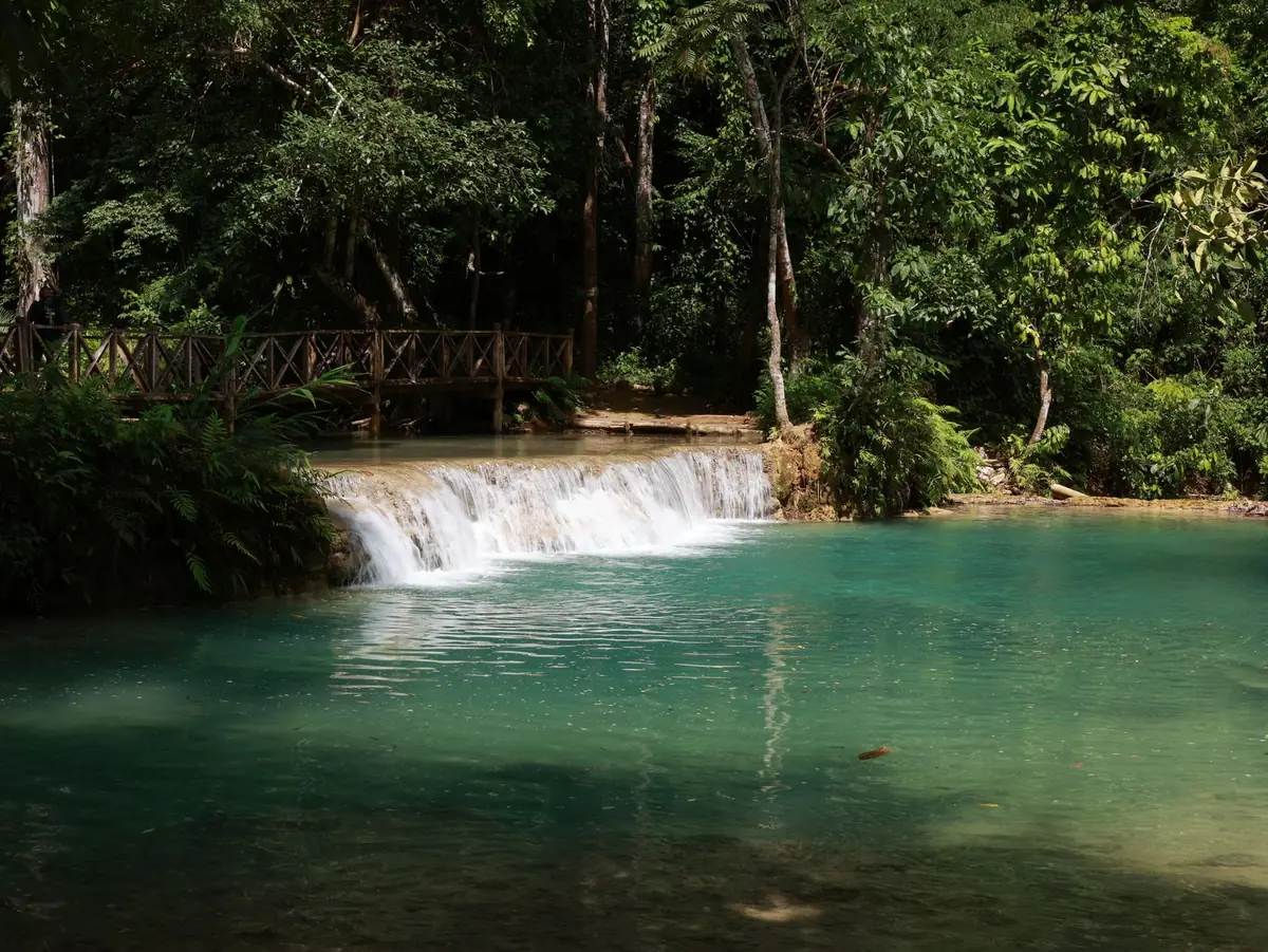The iconic multi-tiered turquoise pools at Kuang Si Falls, accessible by a shared tuk-tuk from the city center.