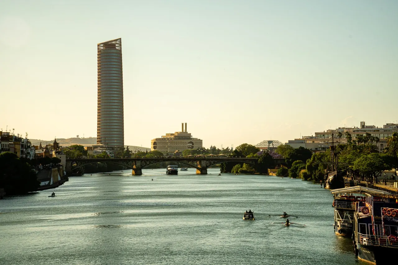 과달키비르 강을 가로지르는 트리아나 다리 위에서 바라본 로맨틱한 석양입니다.